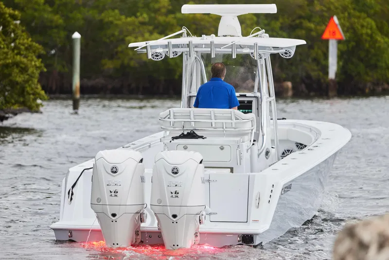 Slide: The Image of 2026 Contender 32 ST boat with dual outboard engines navigating through waterway. - 4