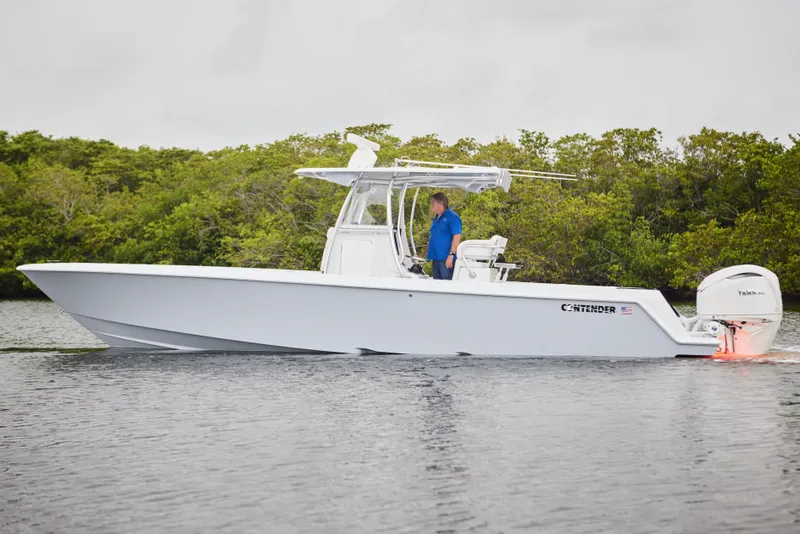 Slide: The Image of 2026 Contender 32 ST boat on water, side view with lush greenery background. - 5