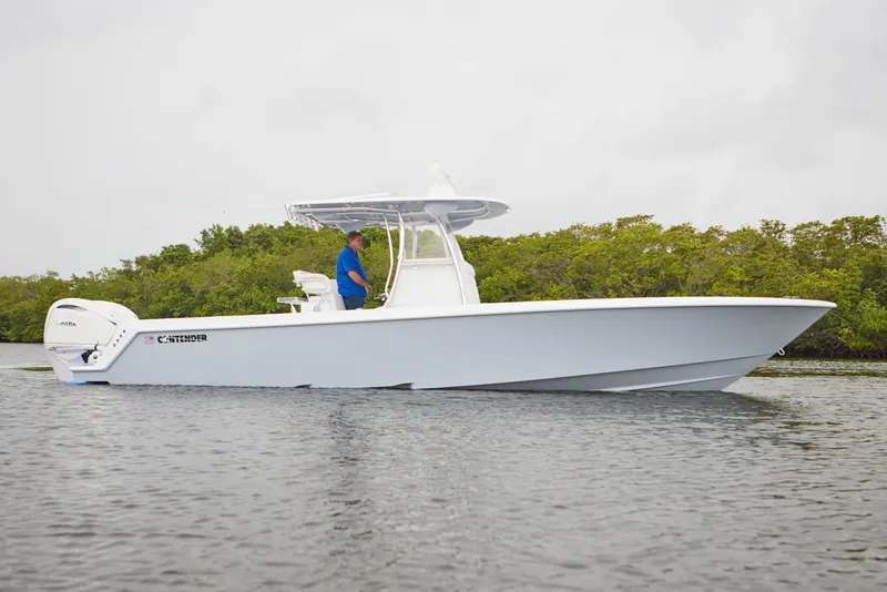 Slide: The Image of 2026 Contender 32 ST boat on water, side view, with lush greenery background. - 6