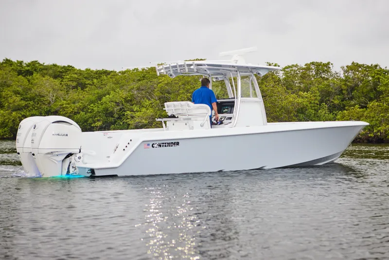 Slide: The Image of 2026 Contender 32 ST boat cruising on water with lush greenery in the background. - 7