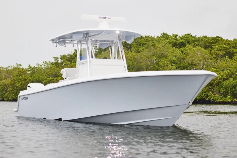 Slide: The Image of 2026 Contender 32 ST boat on water, surrounded by lush greenery. - 8