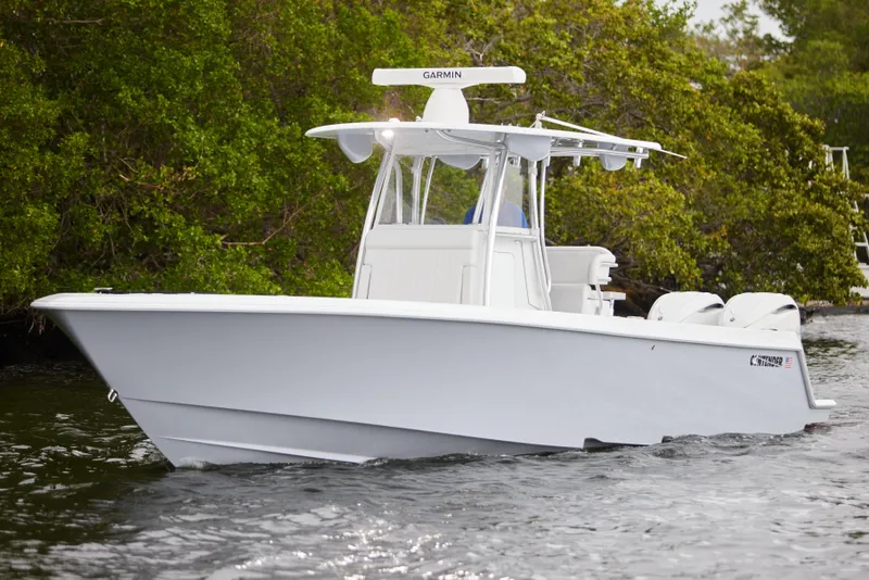 Slide: The Image of 2026 Contender 32 ST boat cruising on water near lush greenery. - 9