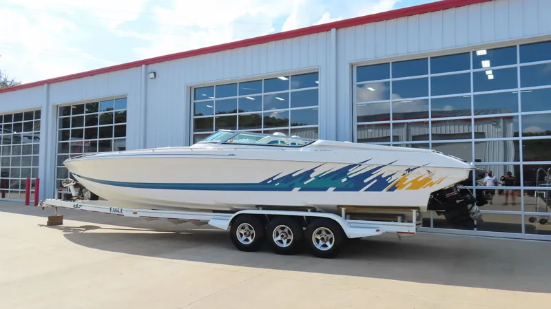 Slide: The Image of 2000 Formula Fastech boat on trailer outside a garage. - 2