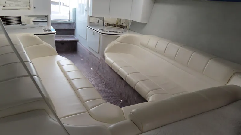 Slide: The Image of Interior of a 2000 Formula Fastech boat with white leather seating and compact kitchen area. - 20