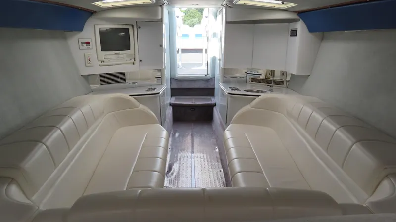 Slide: The Image of Interior of a 2000 Formula Fastech boat with white seating and a compact entertainment area. - 21