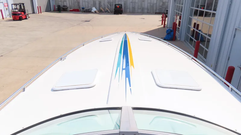 Slide: The Image of 2000 Formula Fastech boat with colorful stripe design, parked near industrial buildings. - 27