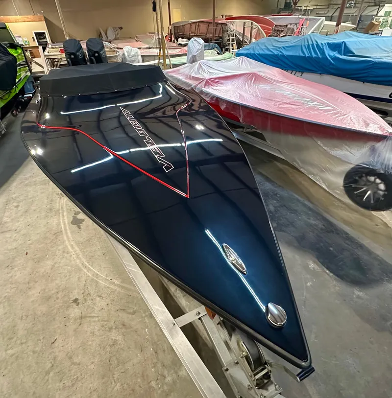 The Image of 2022 Velocity VR1 speedboat in a workshop, sleek black design with red accents. - 0