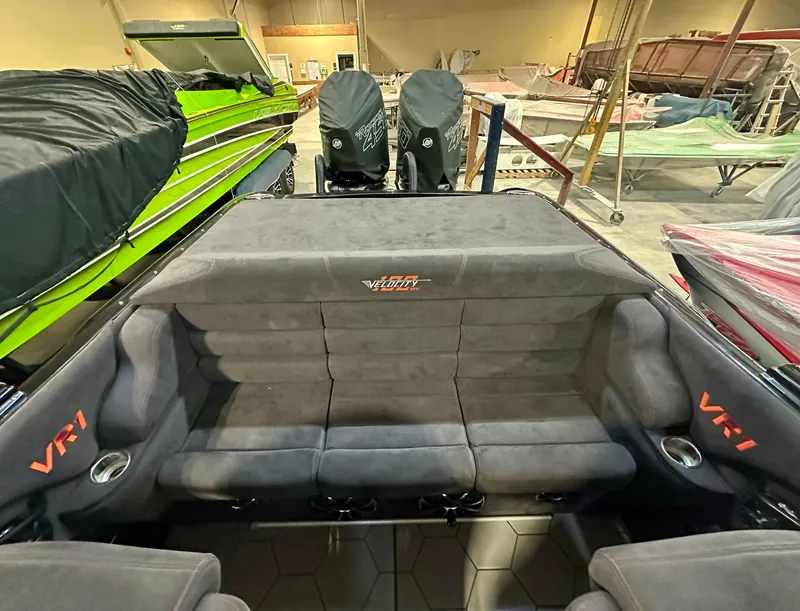 Slide: The Image of 2022 Velocity VR1 boat interior with gray seating and VR1 branding in a workshop. - 22