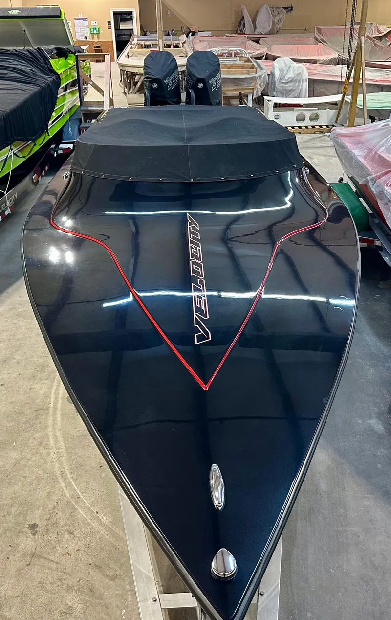 Slide: The Image of 2022 Velocity VR1 speedboat with sleek black design and red accents in a storage facility. - 3
