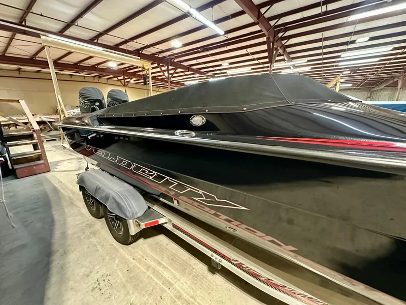 Slide: The Image of 2022 Velocity VR1 boat in storage, black with red accents, on a trailer. - 4