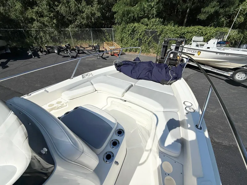 Slide: The Image of 2016 Boston Whaler 210 Dauntless boat interior with seating and console, parked outdoors. - 10