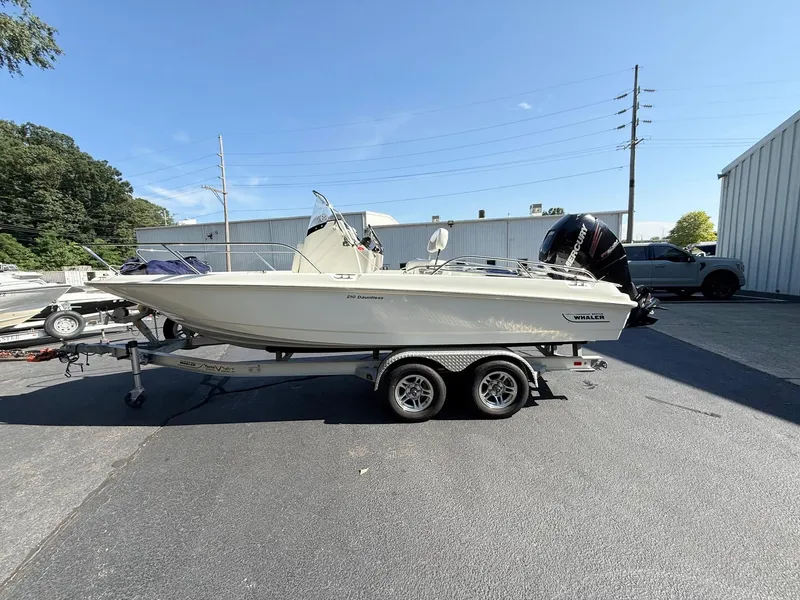 Slide: The Image of 2016 Boston Whaler 210 Dauntless boat on trailer, parked outdoors. - 3