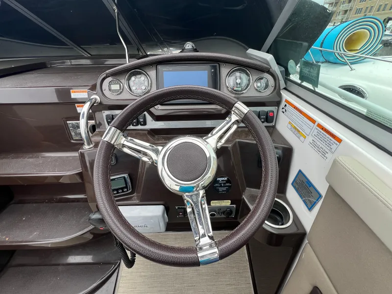 Slide: The Image of 2015 Regal 28 Express boat dashboard with steering wheel and control panel. - 11