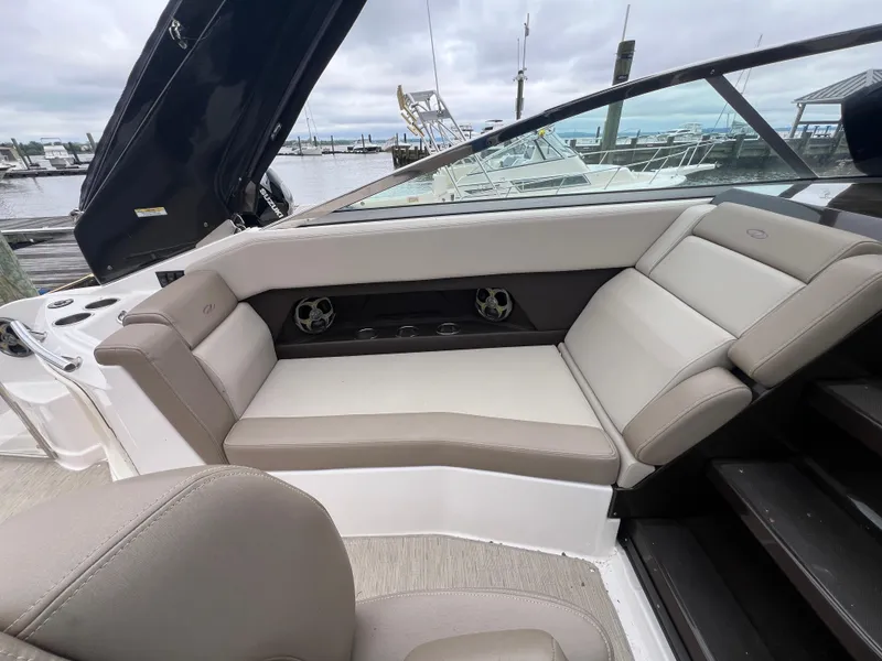Slide: The Image of 2015 Regal 28 Express boat interior with beige seating at a marina. - 12
