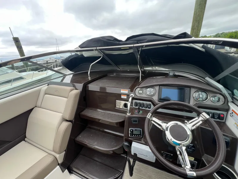 Slide: The Image of 2015 Regal 28 Express boat cockpit with steering wheel and control panel. - 13