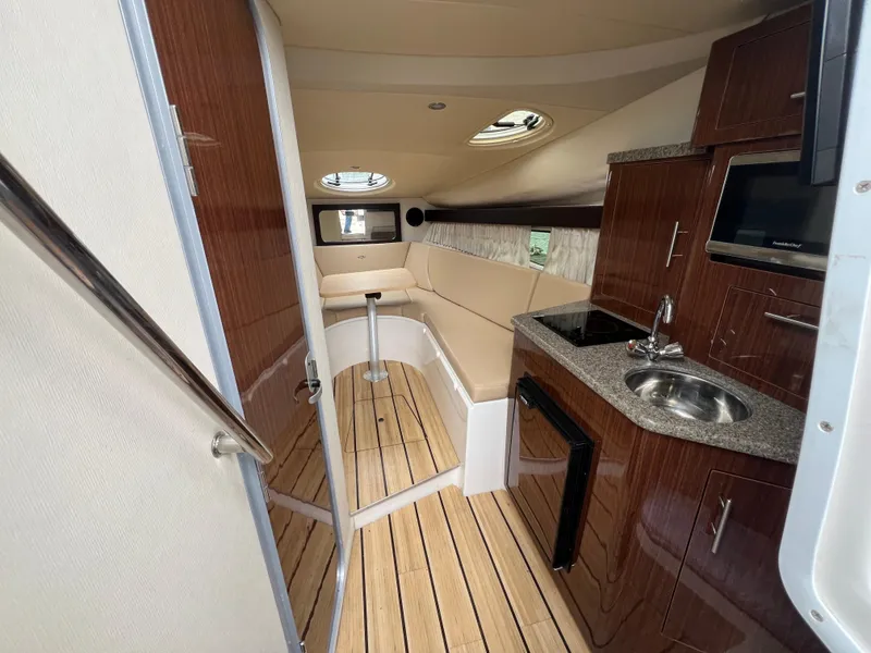 Slide: The Image of Interior of 2015 Regal 28 Express boat with kitchenette and seating area. - 16