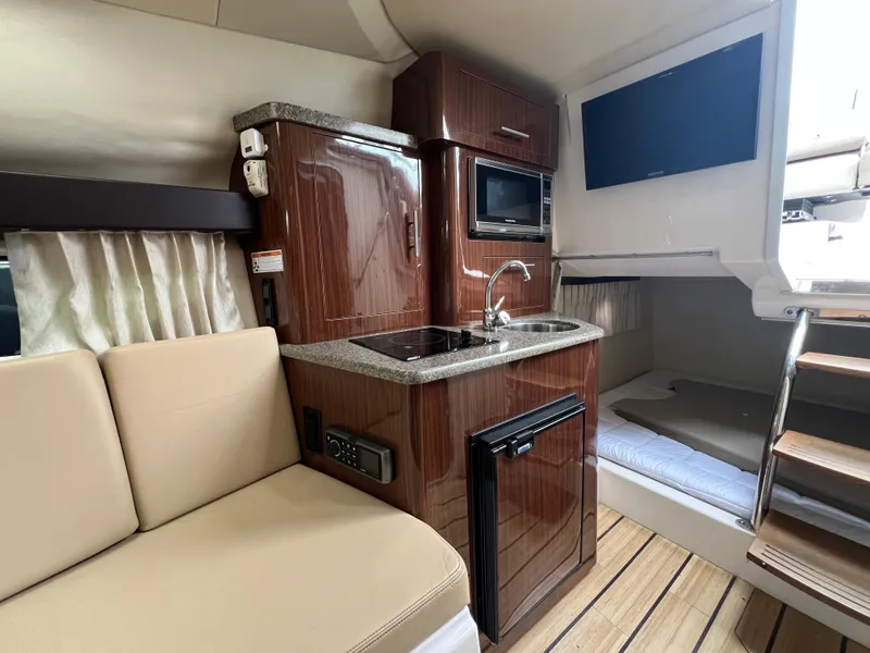 Slide: The Image of Interior of 2015 Regal 28 Express boat with kitchenette, seating, and bed. - 19