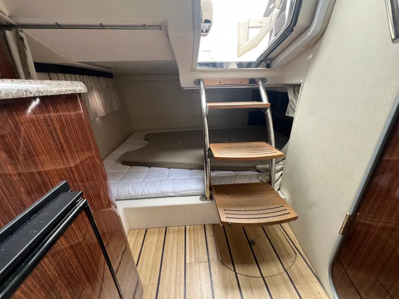 Slide: The Image of 2015 Regal 28 Express cabin interior with wooden steps and cozy sleeping area. - 21