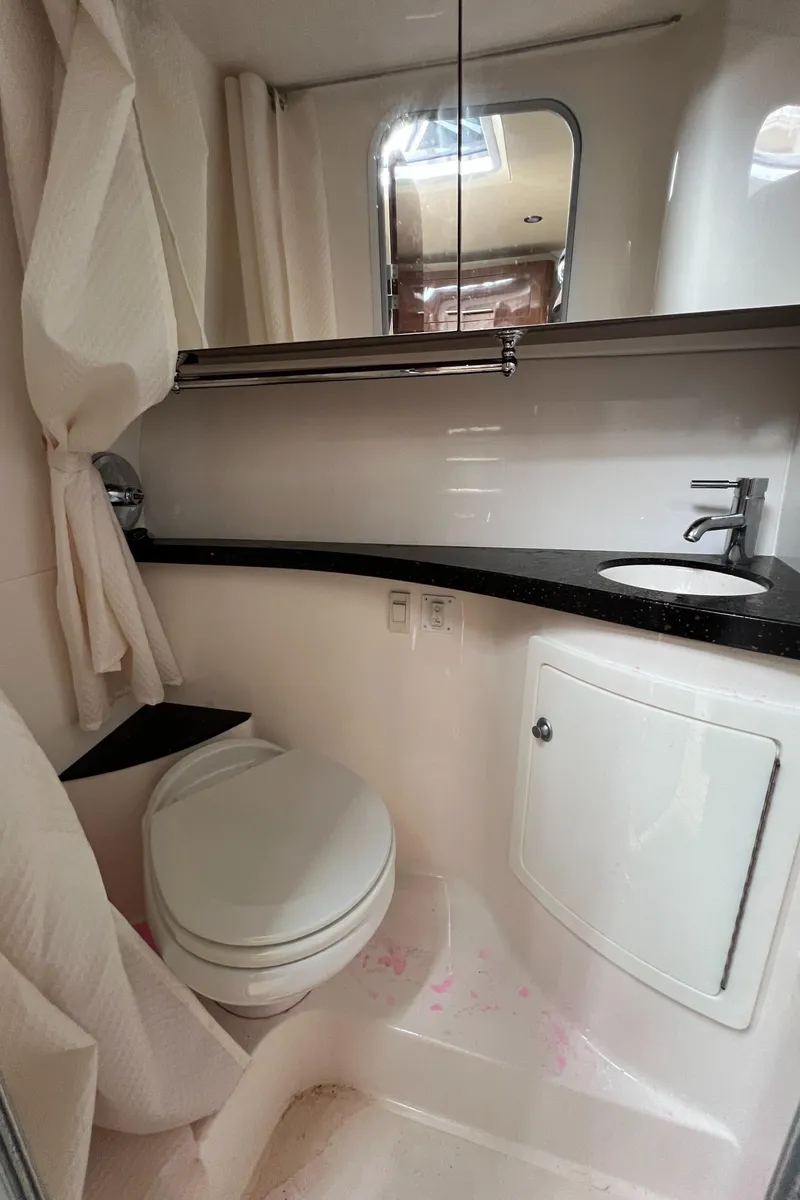 Slide: The Image of 2015 Regal 28 Express boat bathroom with toilet, sink, and mirror. - 23