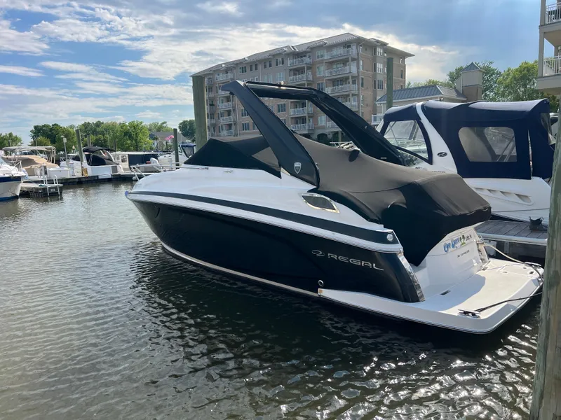 Slide: The Image of 2015 Regal 28 Express boat docked at marina, with modern buildings in background. - 3