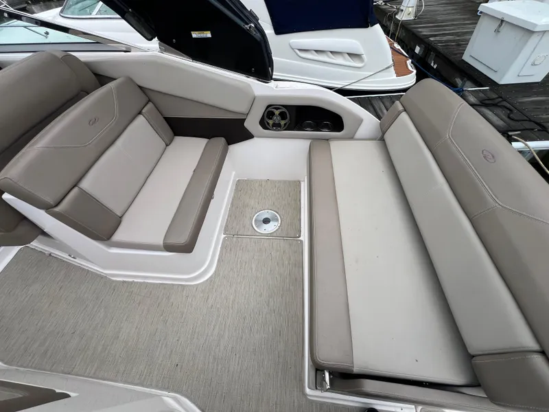 Slide: The Image of 2015 Regal 28 Express boat interior with beige seating and deck. - 7
