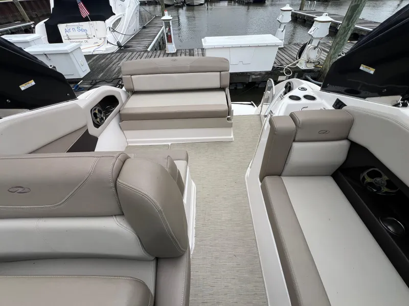 Slide: The Image of 2015 Regal 28 Express boat interior with beige seating, docked at marina. - 9