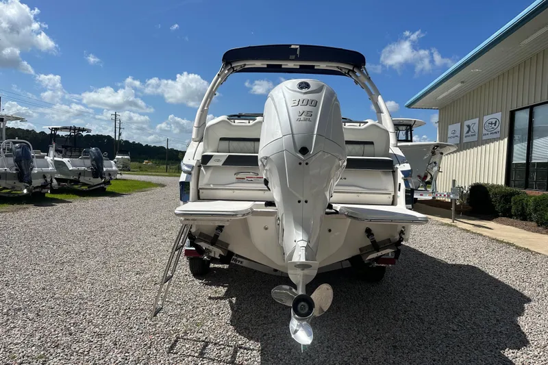 Slide: The Image of 2024 Regal LX4 boat with powerful outboard motor, parked on gravel near dealership. - 8