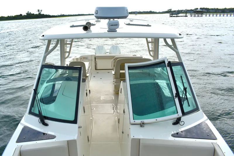 Slide: The Image of 2023 Boston Whaler 320 Vantage boat on water, showcasing spacious deck and windshield. - 10