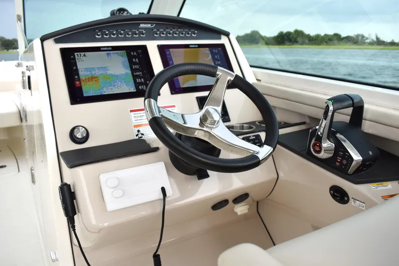 Slide: The Image of 2023 Boston Whaler 320 Vantage helm with modern controls and navigation displays. - 12