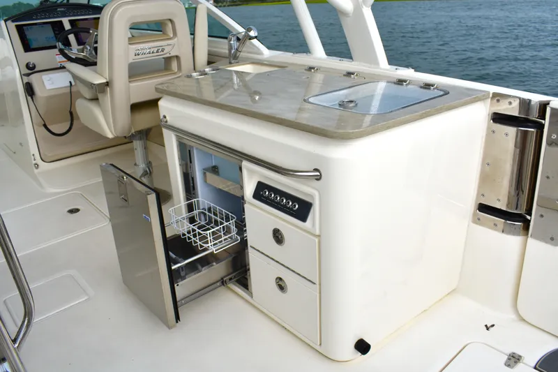 Slide: The Image of 2023 Boston Whaler 320 Vantage boat interior with open fridge and control panel. - 15