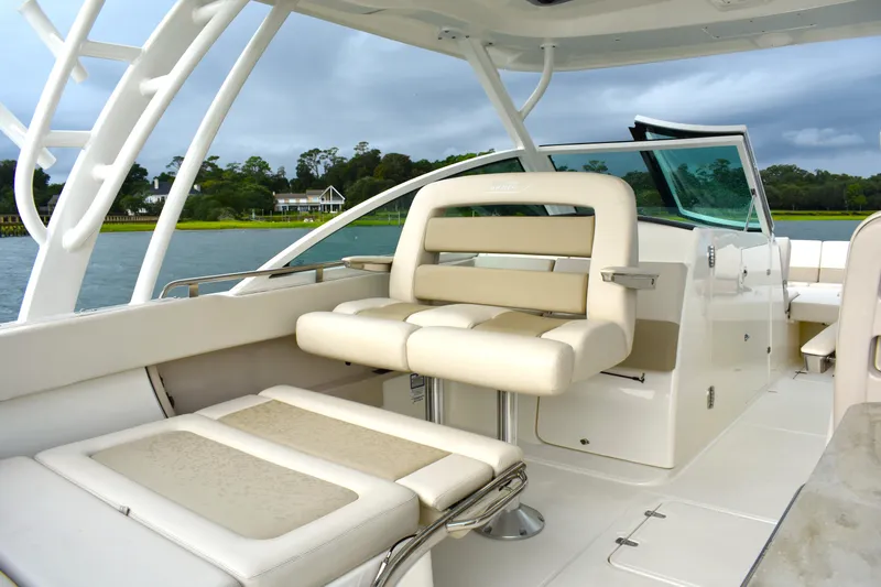 Slide: The Image of 2023 Boston Whaler 320 Vantage boat interior with luxurious seating and scenic water view. - 18