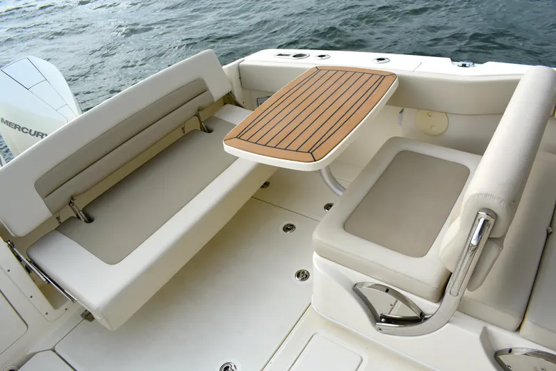Slide: The Image of 2023 Boston Whaler 320 Vantage boat interior with seating and table, on water. - 19