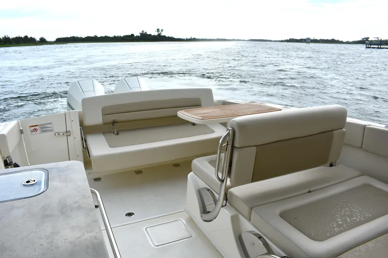 Slide: The Image of 2023 Boston Whaler 320 Vantage boat interior with seating and table on open water. - 20