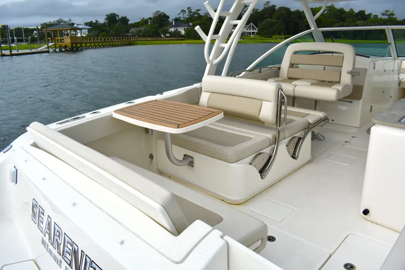 Slide: The Image of 2023 Boston Whaler 320 Vantage boat interior with seating and table on the water. - 22