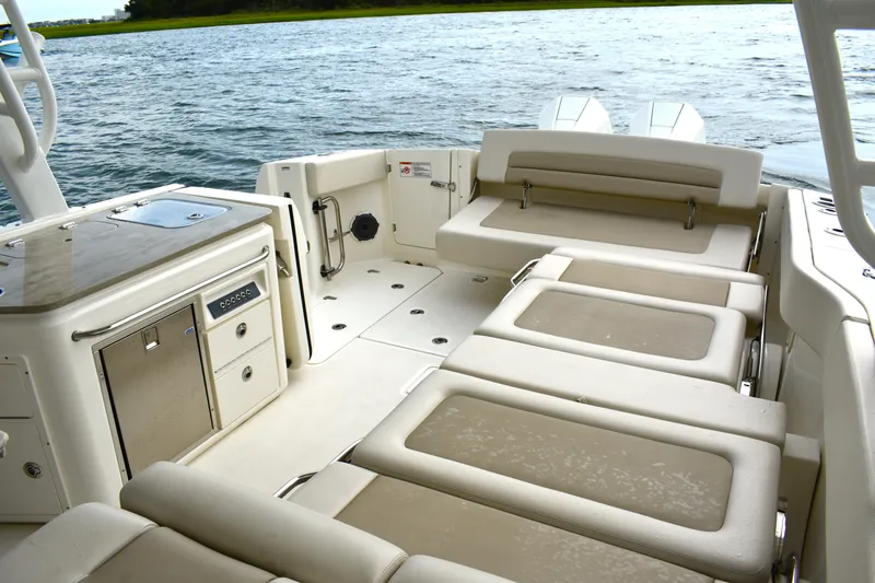 Slide: The Image of 2023 Boston Whaler 320 Vantage boat interior with seating and storage, on calm water. - 27