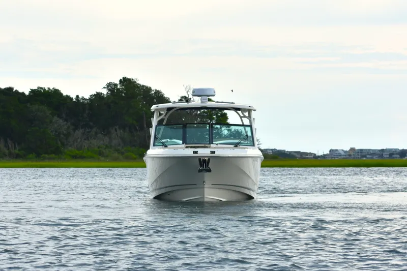 Slide: The Image of 2023 Boston Whaler 320 Vantage boat on calm water with scenic background. - 3