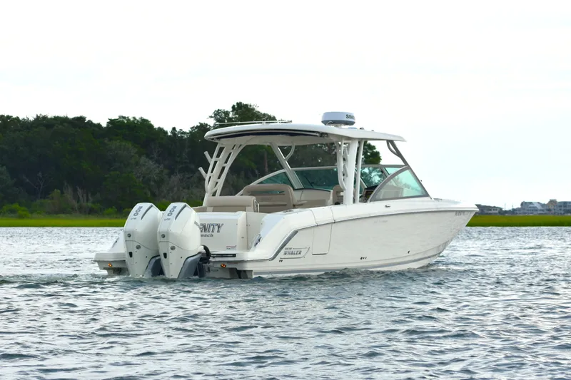 Slide: The Image of 2023 Boston Whaler 320 Vantage boat cruising on a serene waterway. - 6