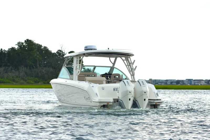 Slide: The Image of 2023 Boston Whaler 320 Vantage boat cruising on a calm waterway. - 7