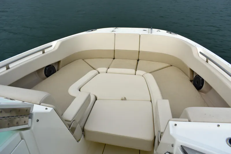 Slide: The Image of 2023 Boston Whaler 320 Vantage boat interior with beige seating and ocean backdrop. - 9