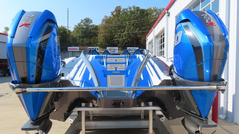 Slide: The Image of Blue 2023 MTI 390X powerboat with dual engines, parked outdoors. - 10