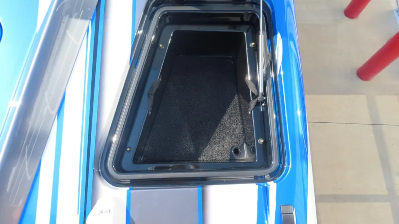 Slide: The Image of Open storage compartment on 2023 MTI 390X boat, blue and white exterior. - 14