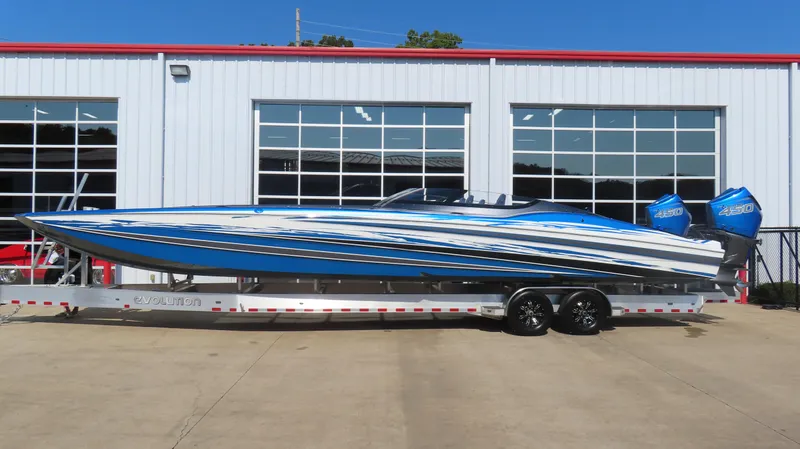 Slide: The Image of 2023 MTI 390X speedboat with blue and white design on a trailer. - 2