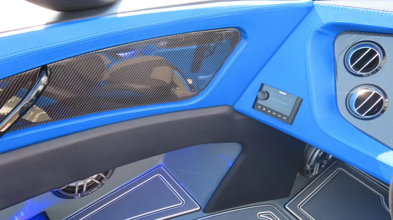 Slide: The Image of Interior of 2023 MTI 390X boat with blue accents and carbon fiber detailing. - 22