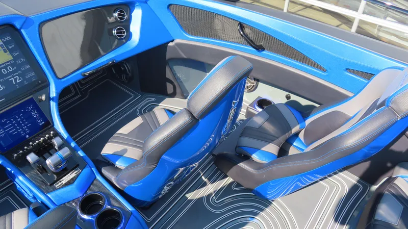 Slide: The Image of 2023 MTI 390X boat interior with blue and gray seating, modern dashboard, and sleek design. - 24