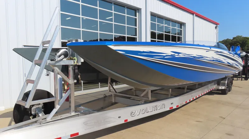 Slide: The Image of 2023 MTI 390X speedboat on trailer, blue and white design, parked outside a building. - 3