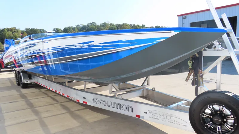 Slide: The Image of 2023 MTI 390X speedboat on trailer, featuring sleek blue and white design. - 5