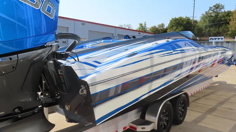 Slide: The Image of 2023 MTI 390X speedboat with blue and white design on a trailer. - 6