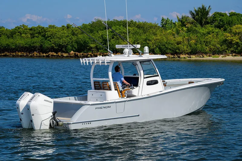 Slide: The Image of 2026 Phenom 34 Center Console boat cruising on a scenic waterway. - 4