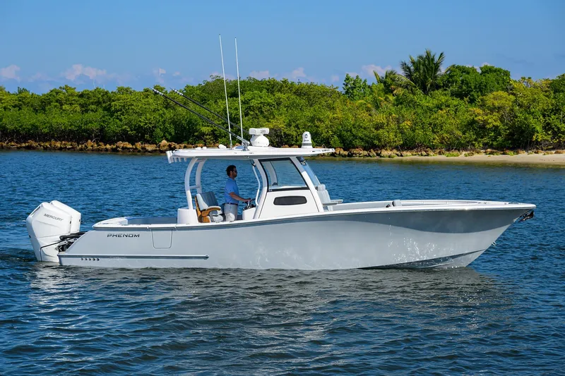 Slide: The Image of 2026 Phenom 34 Center Console boat cruising on a scenic waterway. - 6