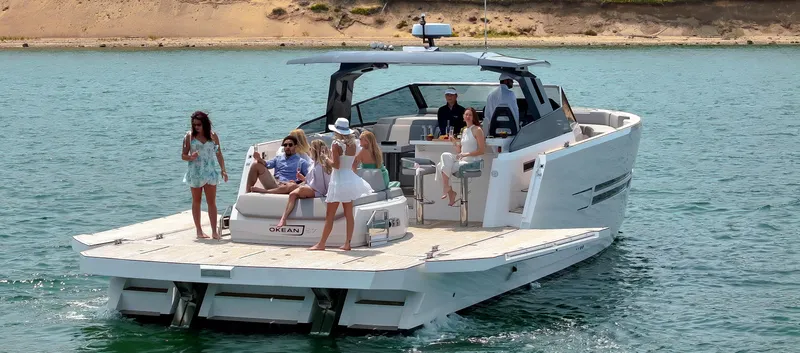 Slide: The Image of Luxury OKEAN 57 yacht cruising with passengers enjoying the sun, 2023 model. - 13